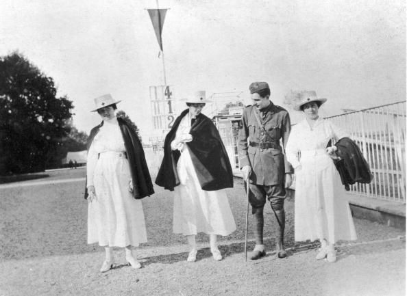 Ernest Hemingway standing outdoors with nurses