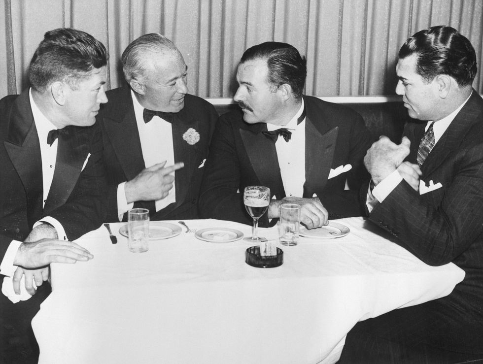 Ernest Hemigway sitting at the table with people in New York